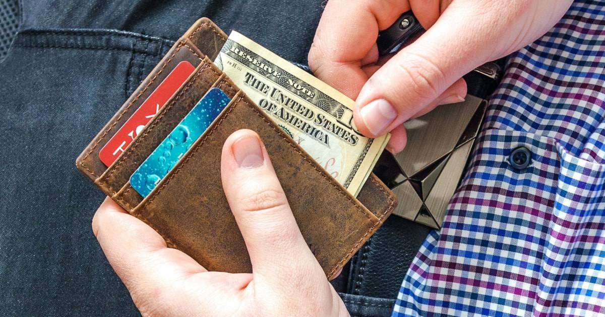 Hombre sentado sacando dinero de la billetera