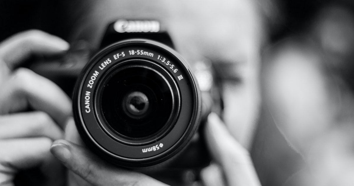 Foto en blanco y negro del lente de una cámara Canon