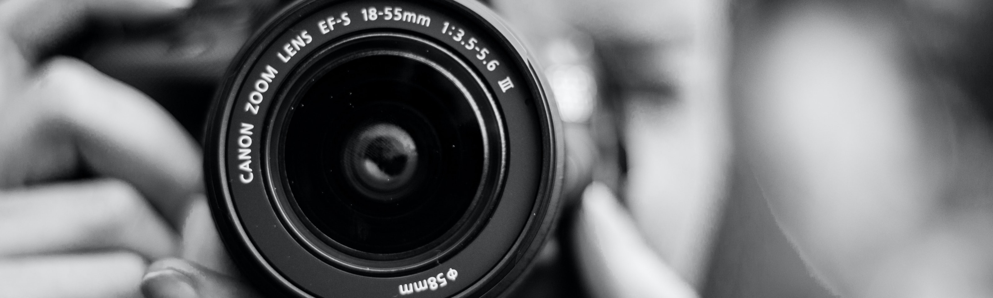 Foto en blanco y negro del lente de una cámara Canon
