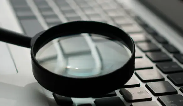 A magnifying glass over a laptop keyboard